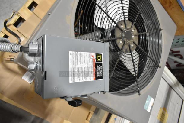 Rheem 13PJA24A01 air conditioner condenser in metal, 208/230V, 1 phase, visible labels, on wooden pallet, good condition.