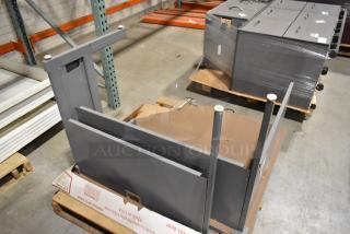 Gray desk pieces on pallets, unpackaged. Includes tabletops and legs. New condition, ideal for office setup.