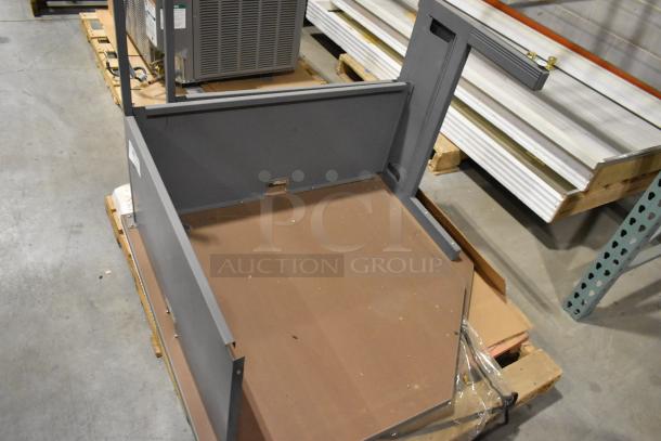 Gray desk pieces with metal frame, partial assembly, visible labels; auction for two units.