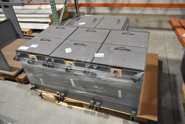 Four gray 2-drawer filing cabinets on casters, stacked and wrapped in plastic. Each drawer has a handle and label slot. Condition appears new.