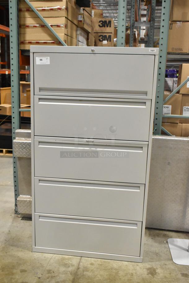 Gray metal filing cabinet with 4 drawers and 1 door, in good condition. Auction Lot 96 tag visible.
