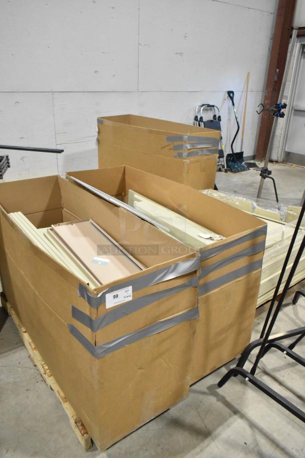 Three pallets of various metal panels in large cardboard boxes, secured with tape. Label reads "99 3x your bid."