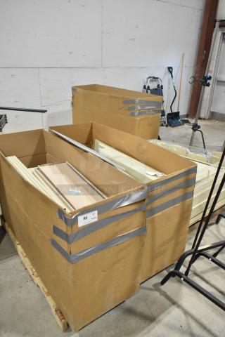 Three pallets of various metal panels in large cardboard boxes, secured with tape. Label reads "99 3x your bid."