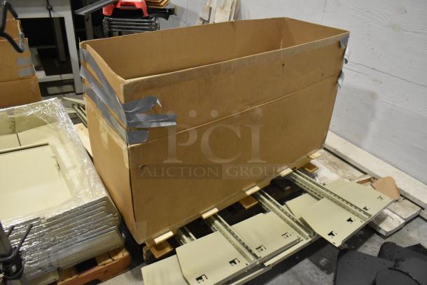 Three pallets of various metal panels in large cardboard boxes, secured with duct tape, on wooden pallets in warehouse.