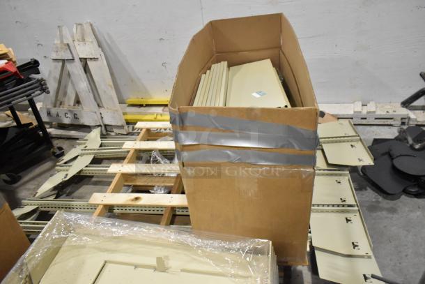 3 pallets of various metal panels in a warehouse. Panels appear unused, stacked in open cardboard with visible tape.