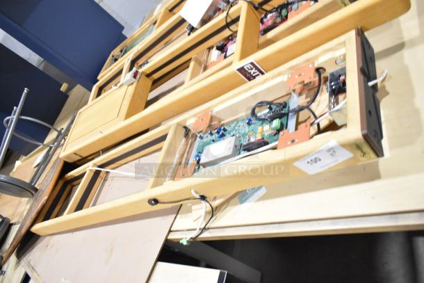 Five Signature Series wooden tables with integrated electronics, showcasing wiring and circuit boards. Suitable for tech applications.