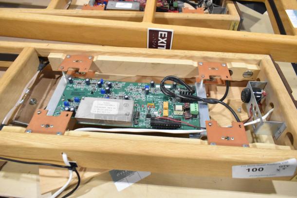 5 Signature Series wooden tables showcasing integrated electronics, sturdy condition, labels indicating auction lot number and website.