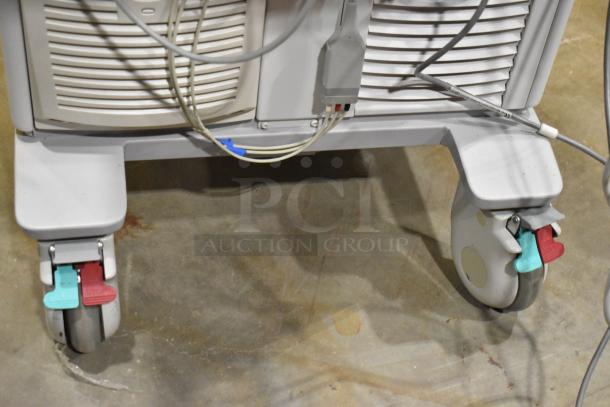 Philips M2540A Ultrasound System on casters, showing base and cables. Features mobility with locking wheels. Condition visible.