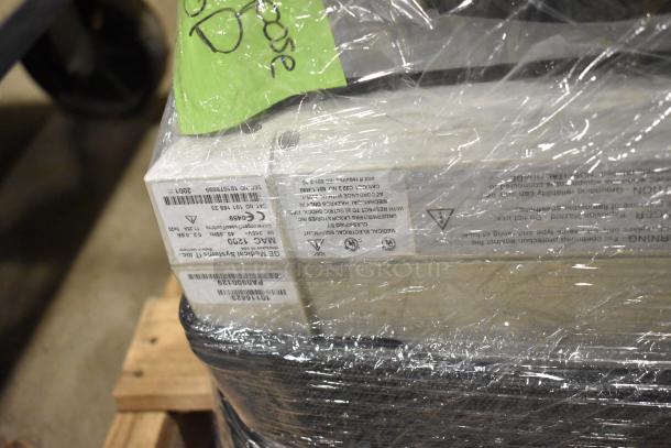 Pallet with Bionet CardioTouch-3000 and GE MAC1200 EKG machines, wrapped in plastic. Labels indicate model details.