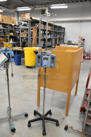 3 medical items: 2 Alaris Signature Edition infusion systems and 1 stand, all on casters. Good condition.