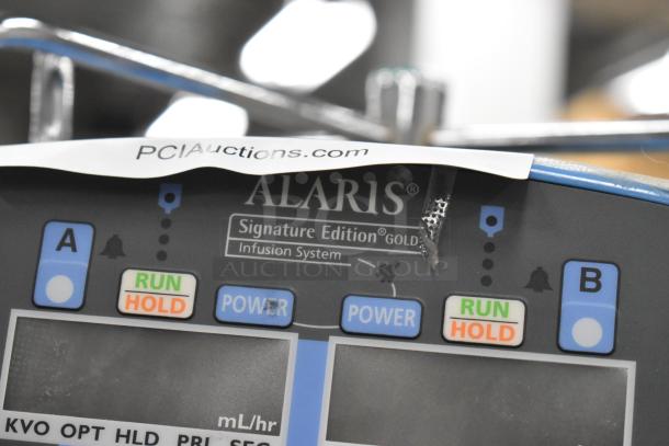 Alaris Signature Edition Infusion System on casters, control panel with run and hold buttons visible, labeled "Infusion System."
