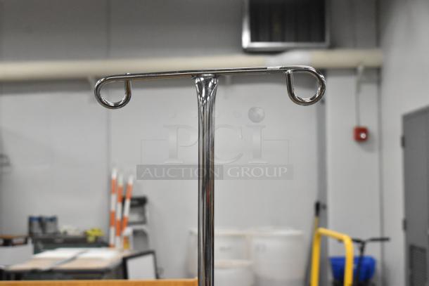 Alt text: Metal stand with rounded hooks, part of a medical infusion system, shown in a warehouse setting.