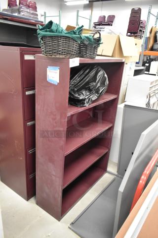 Maroon metal bookshelf with three shelves, alongside a maroon 5-drawer filing cabinet. Labels indicate storage use.