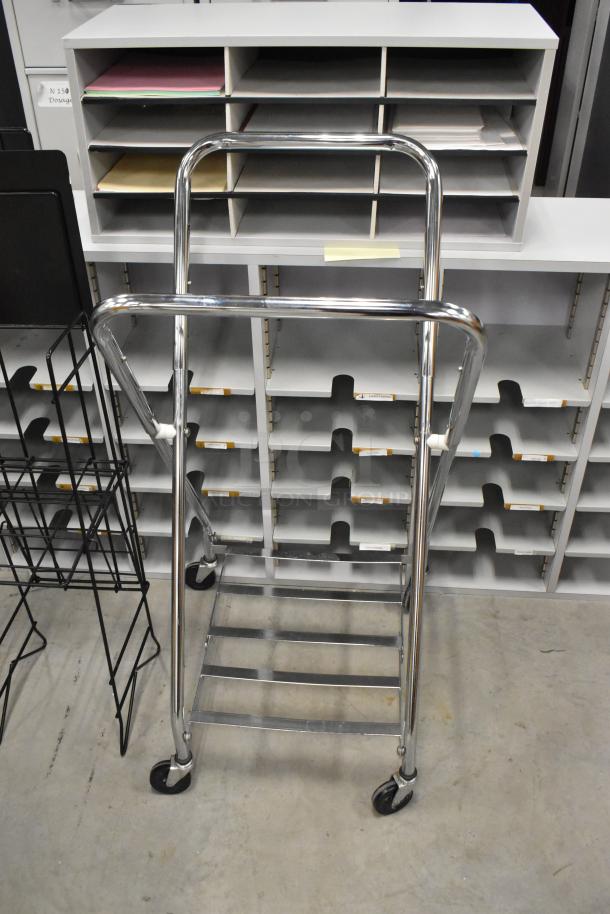 Chrome laundry bag frame on casters and black newspaper stand, both in good condition. Two items included in auction.