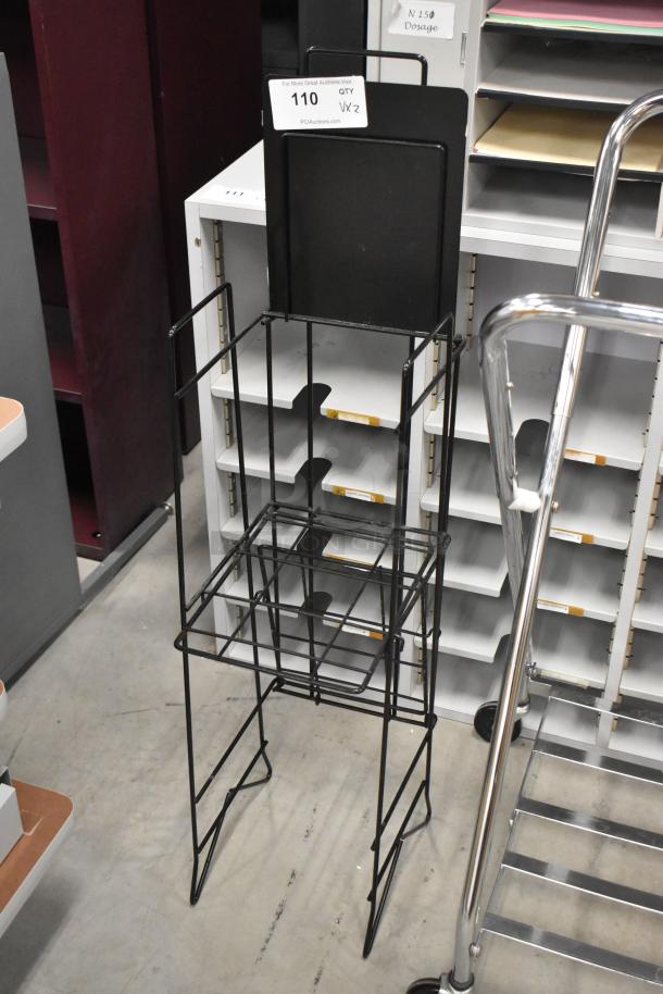 Laundry bag frame on casters and newspaper stand, metal, black finish. Includes auction tag indicating quantity x2.