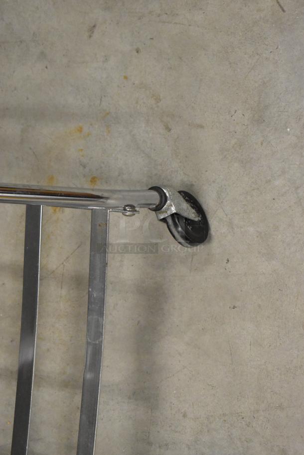 Laundry bag frame on casters, metal construction, sturdy condition, showing wheel detail on concrete background.