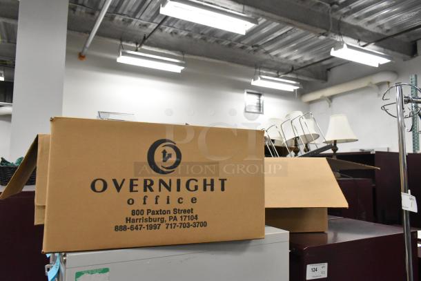3 boxes containing staplers, rack, bins, and miscellaneous items. Visible box labeled "Overnight Office" with address.