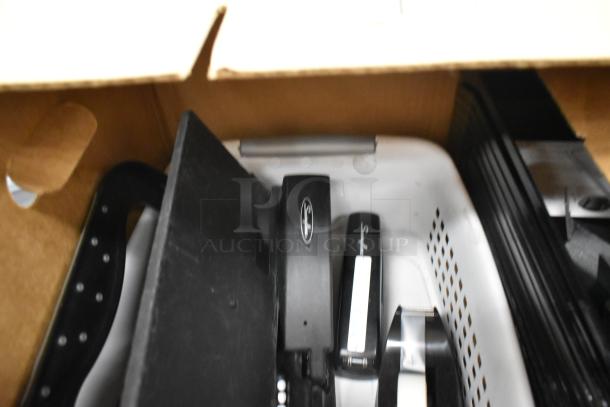 Boxes containing staplers, rack, and bins inside a white container. Items appear gently used.