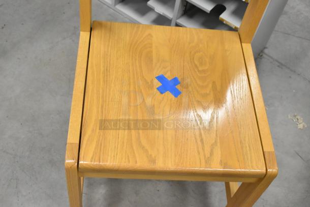 Wood pattern chair with a light finish, featuring a blue tape marking on the seat. Appears in good condition.