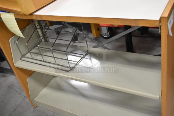 Wood-pattern bookshelf with metal basket, two shelves. Condition appears used. Includes tag with unspecified notes.