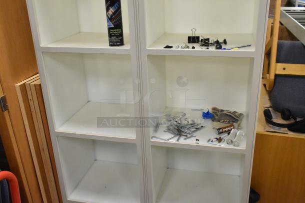 White 8 cubby shelving unit with scattered hardware in some cubbies. Good condition, ideal for storage or display.