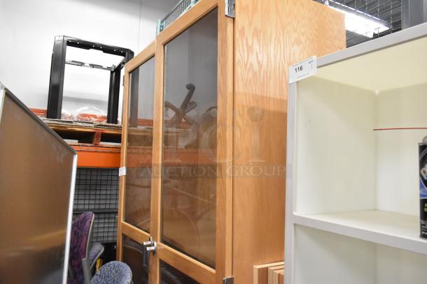 Wooden 2-door merchandising cabinet with glass panels, silver handles, and light wood finish. Excellent condition.