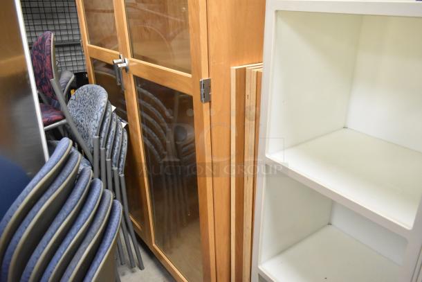 Wooden two-door merchandising cabinet with glass panels, metal handles, and hinges. Appears in good condition.