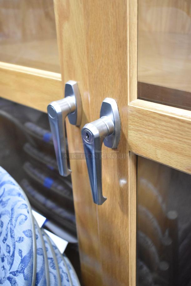 Wooden 2 Door Merchandising Cabinet with glass panels and metal handles, in good condition.