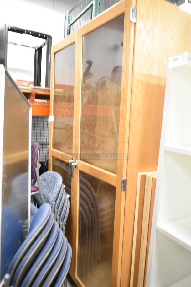 Wooden 2 Door Merchandising Cabinet, transparent panels, sturdy hinges, good condition, ideal for display or storage.