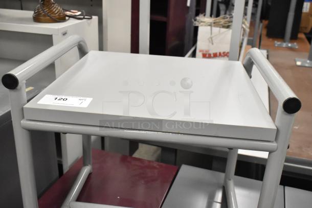 Gray table with metal frame and flat surface, minimal wear. Auction tag reads "120."