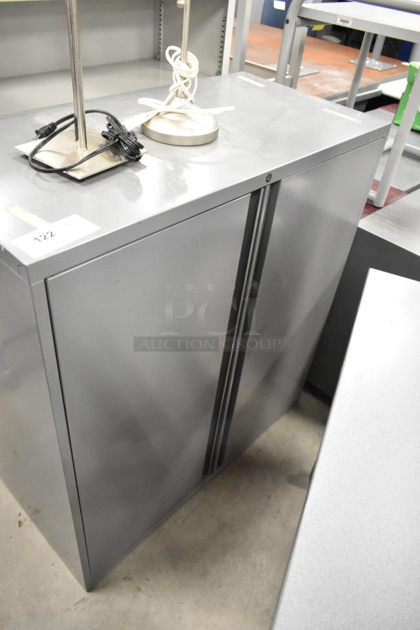 Gray metal 2-door cabinet, sleek design, excellent condition, suitable for office or home storage. Includes label "122".