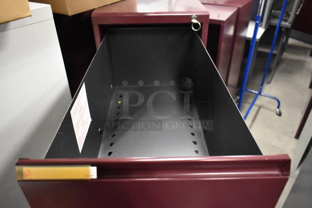 Maroon metal 4-drawer filing cabinet, open drawer showing interior. Used condition, durable design, visible label inside.