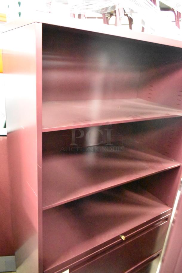 Maroon metal bookshelf with three shelves, minimal wear, sturdy construction, ideal for office or home storage.