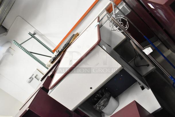 2 light gray desks with overhead cabinets in good condition, featuring burgundy trim and key locks, in an auction setting.