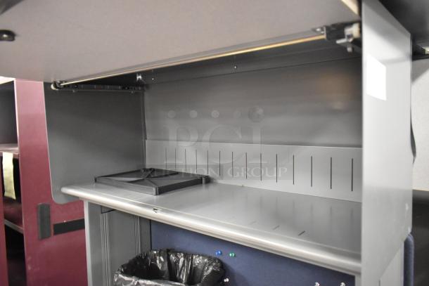 Two light gray desks with overhead cabinet, featuring slotted panels and a built-in shelf. Minor wear visible.