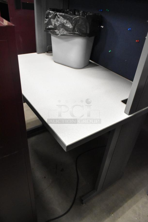 Light gray desk with overhead cabinet, metal frame, and integrated cable management, in good condition.