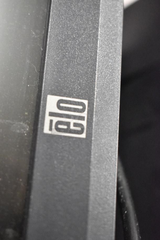 Elo POS Monitor, close-up view of the Elo logo on the monitor's dark gray frame, showing minimal wear.