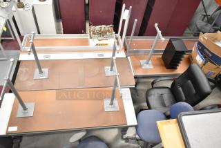 10 various gray tables with disassembled legs, showing wear. Includes office chairs and boxes. Sold as a lot, 10 times bid.