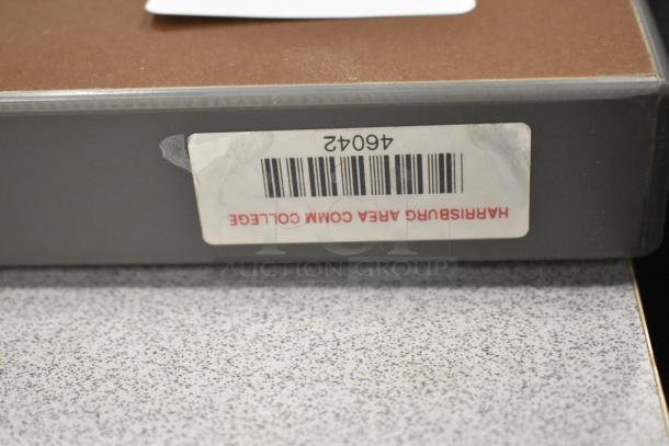 Gray table edge with a barcode label from Harrisburg Area Community College, indicating item number 46042.