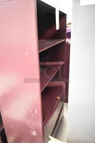 Two metal bookshelves; one maroon, one gray. Features multiple shelves, visible wear on maroon surface. Auction lot includes both.