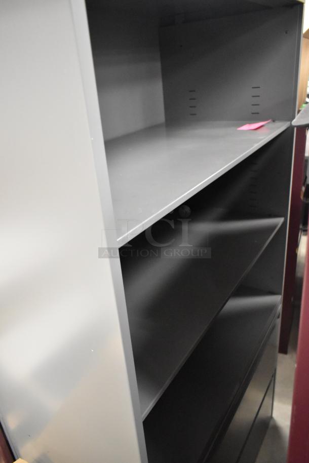 Two metal bookshelves, one maroon and one gray, in good condition. Sturdy design with adjustable shelves.