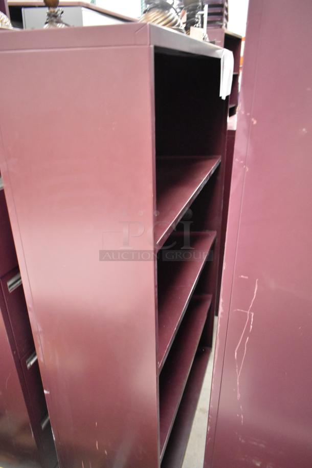 Maroon metal book shelves with three shelves each. Slightly worn with visible scratches. Auction offers two shelves.