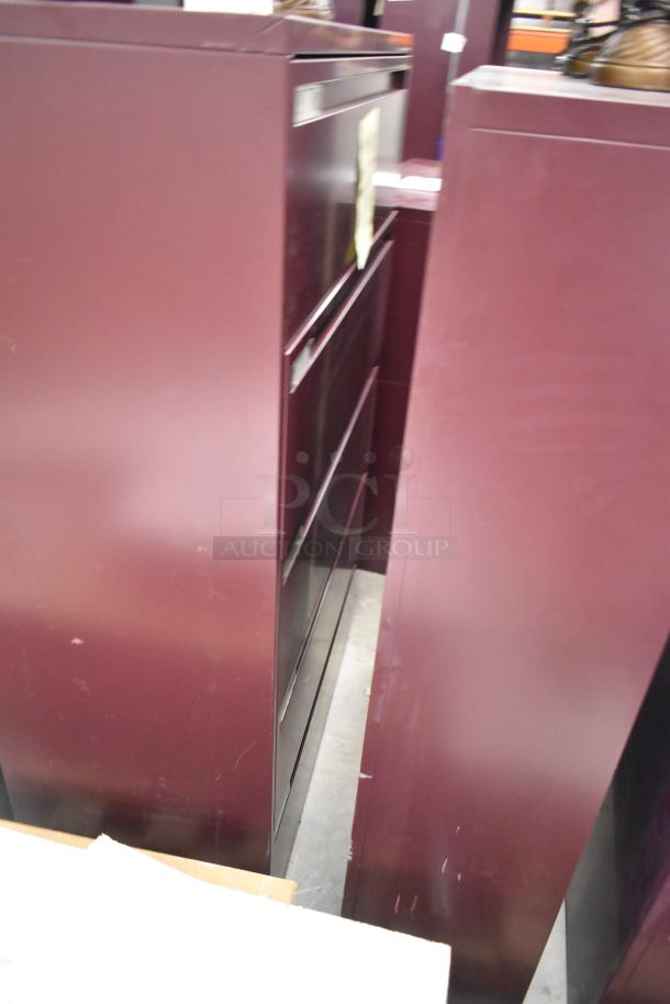 Two maroon metal bookshelves, visible wear, sturdy build, ideal for storage, featuring multiple shelves.