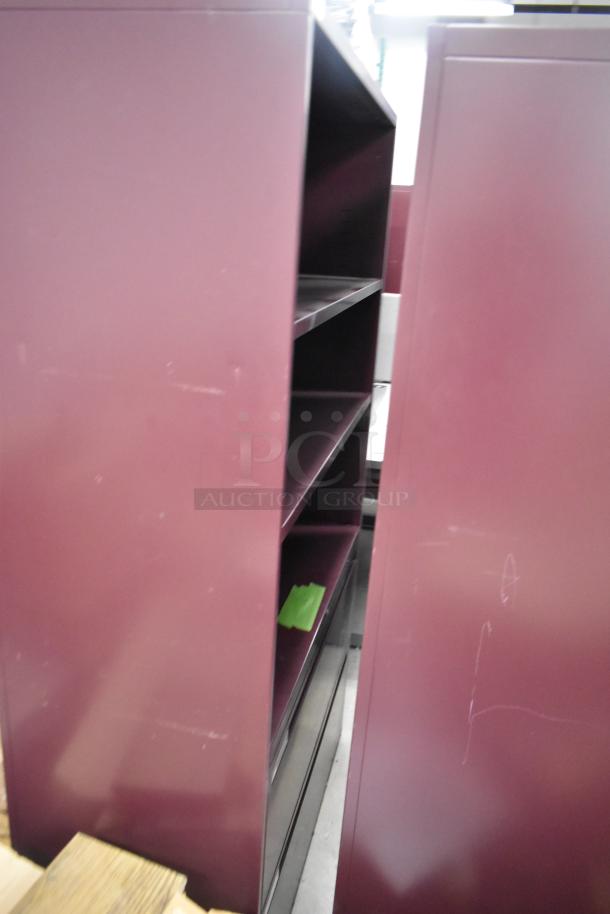 Two metal maroon bookshelves with multiple shelves, in used condition. Ideal for storage or display.