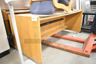 Wood pattern desk with a light finish, simple design, and ample legroom. Visible tag indicates item number 143. Good condition.
