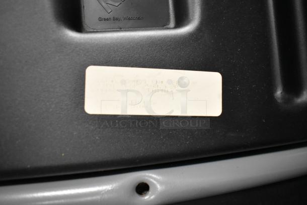 Auction lot of 38 assorted chairs. Close-up shows a manufacturer's label from Green Bay, Wisconsin. Some wear visible.