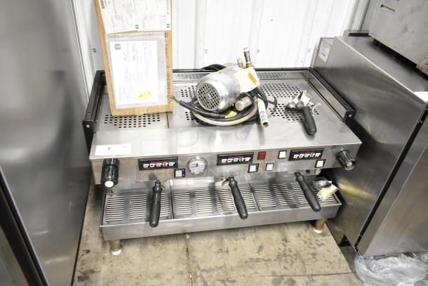 La Marzocco Firenze stainless steel 3-group espresso machine with 3 portafilters, steam wands, and visible control panel.