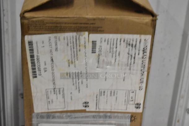 Cardboard box with shipping labels and markings, appears unopened. Labels show item details and destination information.
