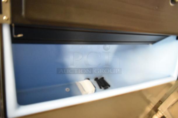 2022 Ice-O-Matic CIM1446HW6 stainless steel ice machine interior, showing blue commercial ice bin and components.