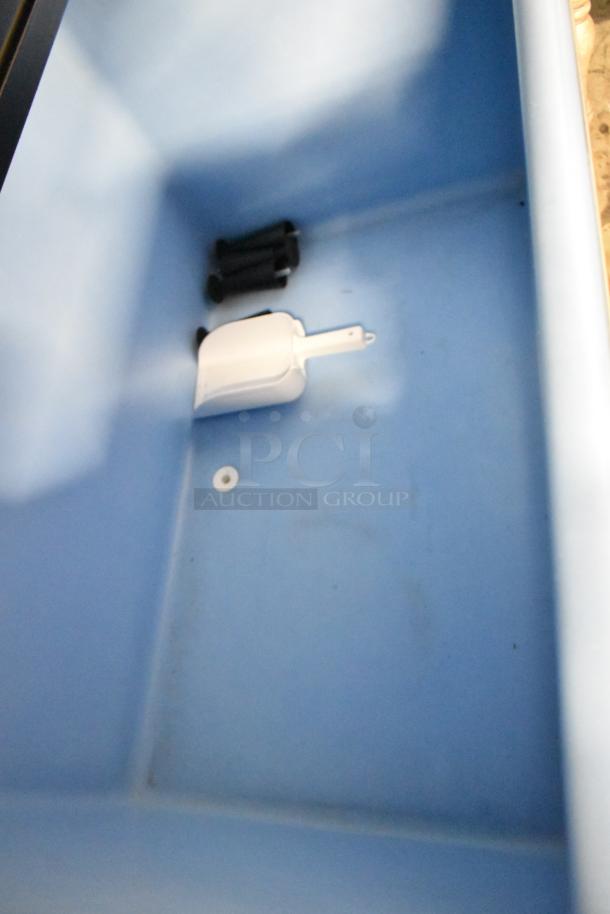 Ice bin interior of 2022 Ice-O-Matic CIM1446HW6, visible ice scoop and components, commercial machine, stainless steel.